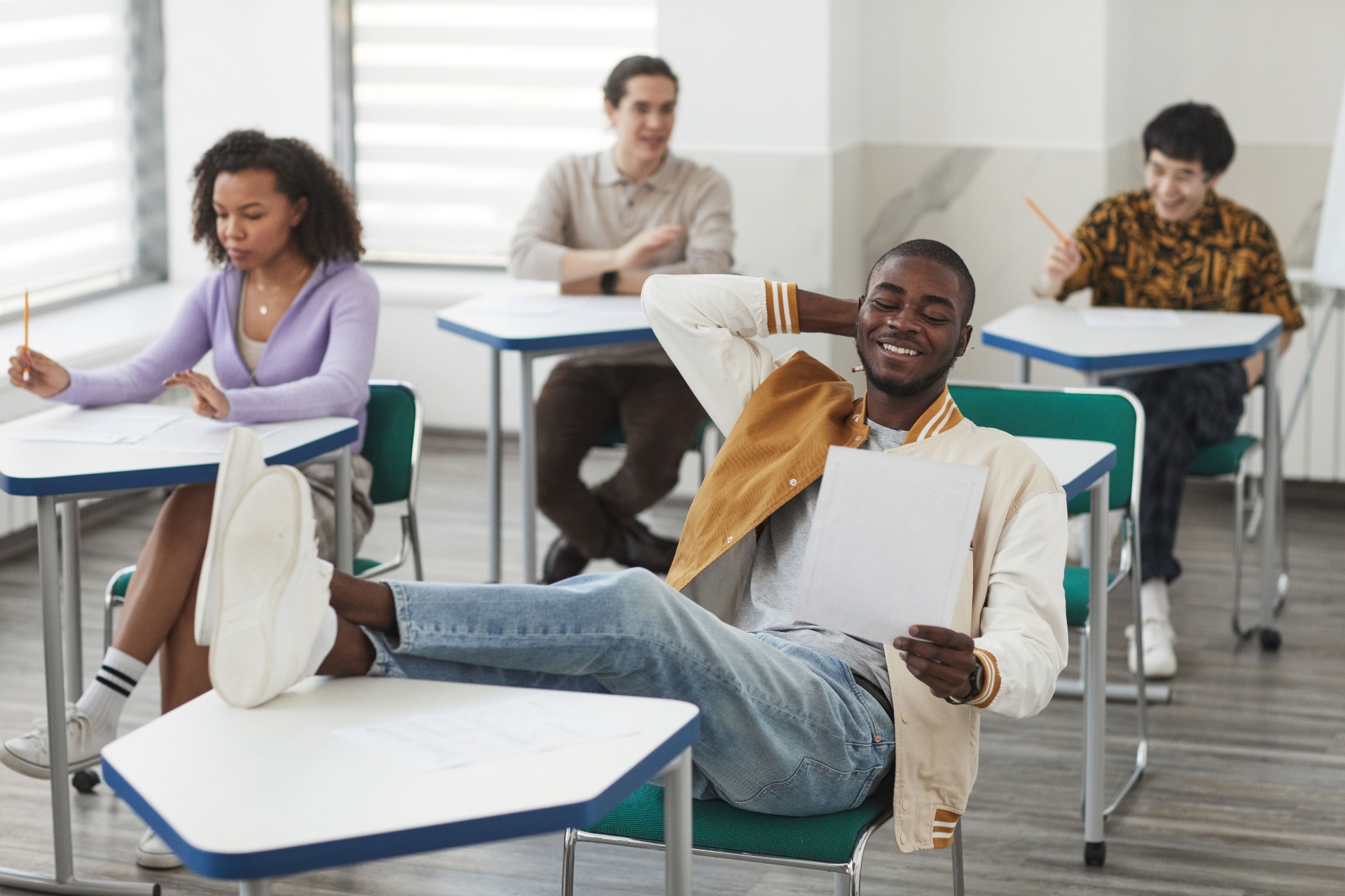 African American graduate laughing with Hispanic friends on campus