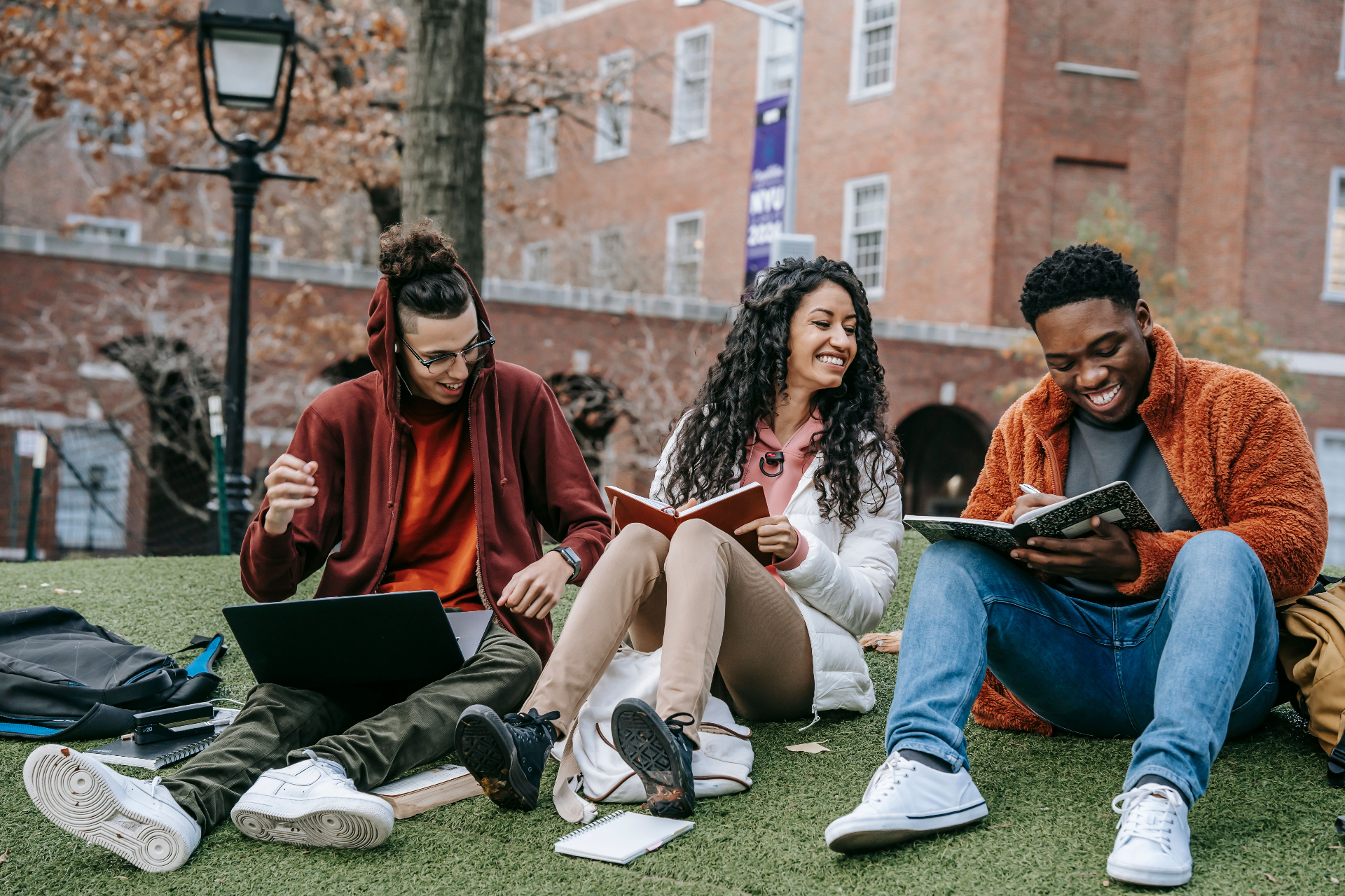 Black and Latino students studying together with laptops